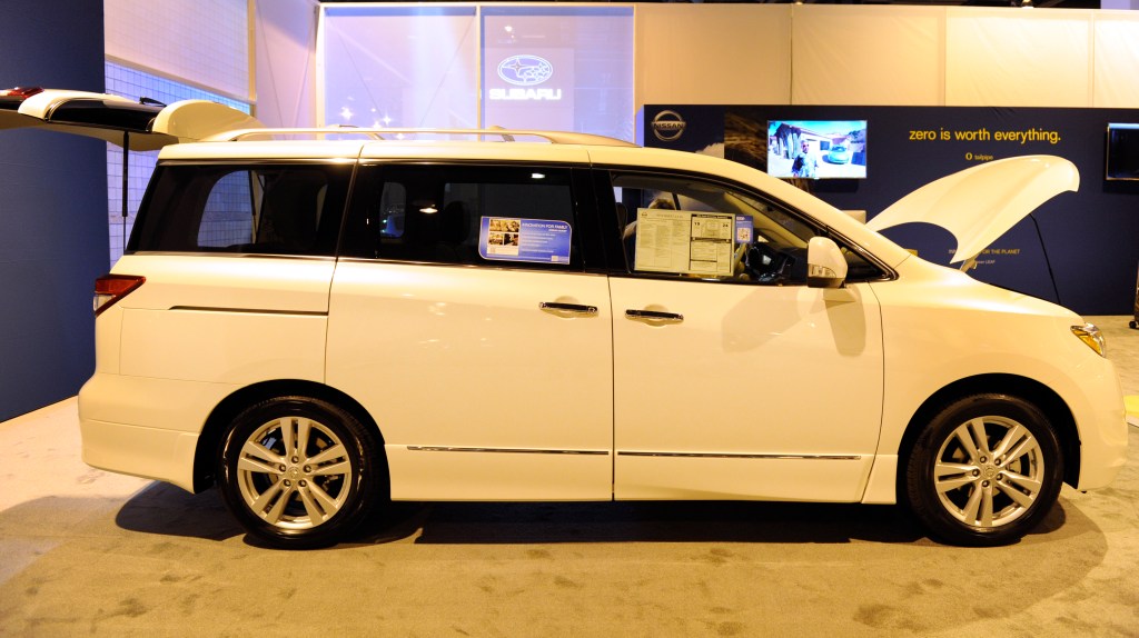 a white 2012 Nissan Quest minivan on display at an auto show 