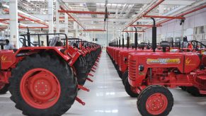 a line of Mahindra Tractors in a manufacturing facility