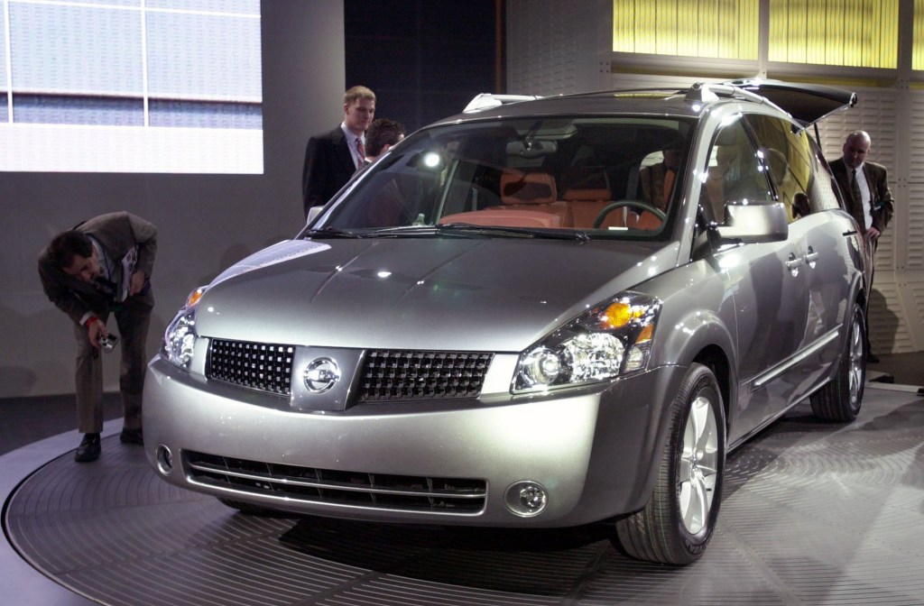 a silver Nissan Quest minivan model at an auto show on display 