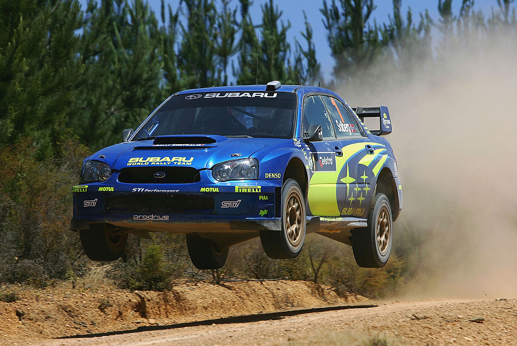 The blue and yellow Subaru WRX rally car airborne in Perth