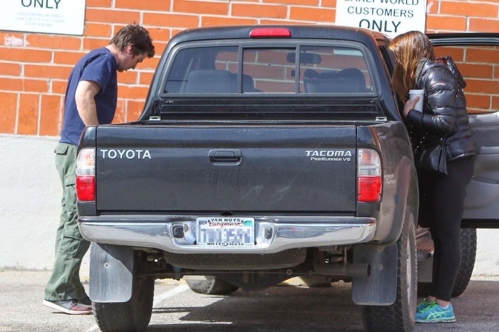 Actor Christian Bale and wife Sibi getting into their old black Toyota Tacoma TRD Off-Road PreRunner V6