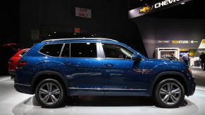 A dark blue Volkswagen Atlas on display at a car show side view photo