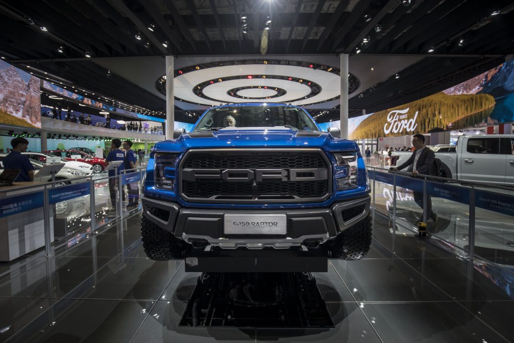 A blue Ford F-150 Raptor on display at an auto show 