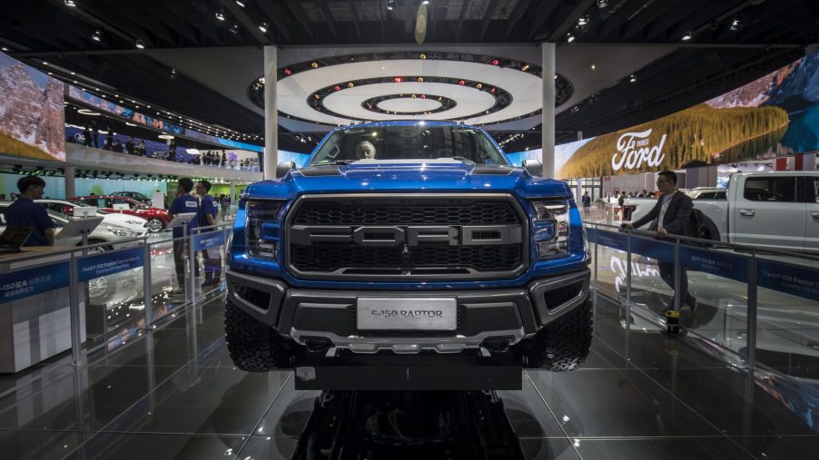 A blue Ford F-150 Raptor on display at an auto show