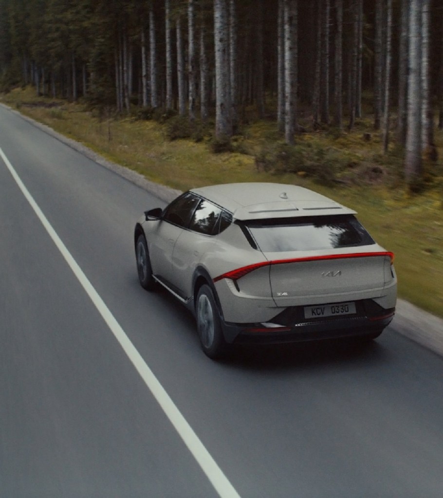 An ecru 2022 Kia EV6 races down the highway.