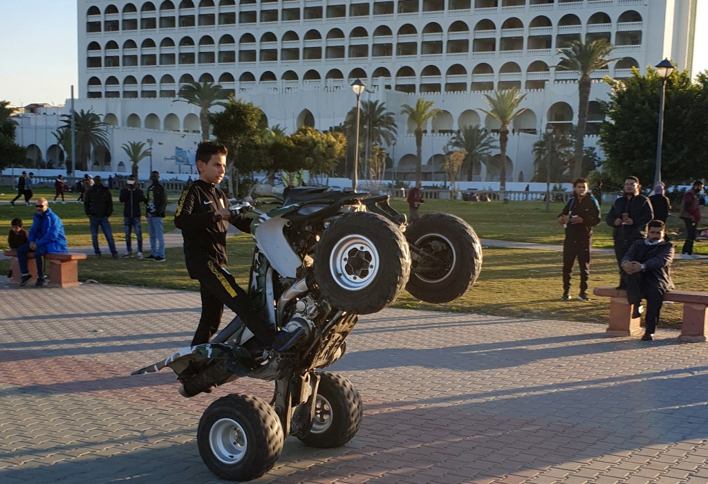 A Libyan boy performs a wheelstand ("wheelie") maneuver with an all-terrain vehicle (ATV) at a park in the capital Tripoli near the Martyrs' Square