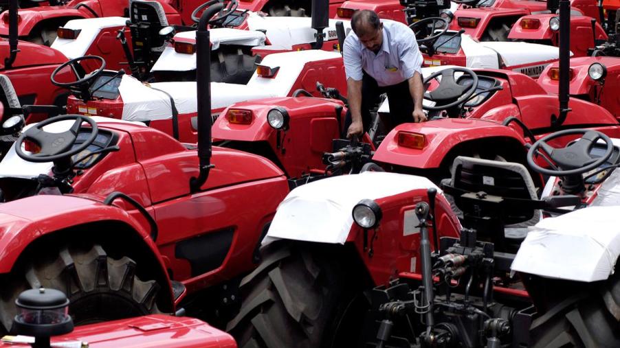 A person working on a Mahindra tractor.