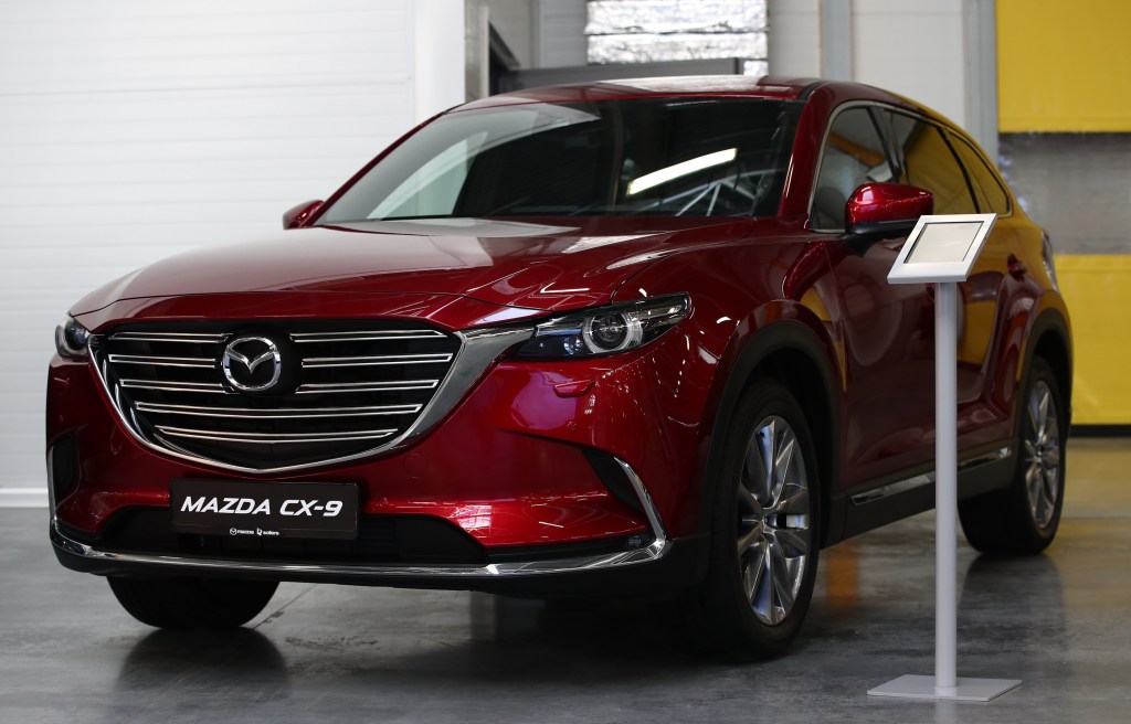 A red Mazda CX-9 SUV on display at a Mazda Sollers Manufacturing car factory during a visit by the president of Russia and the prime minister of Japan