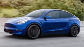 A blue Tesla Model Y is being tested on a closed track.