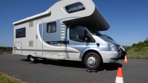 A motorhome RV stands with its wheels on a scale of the ADAC.