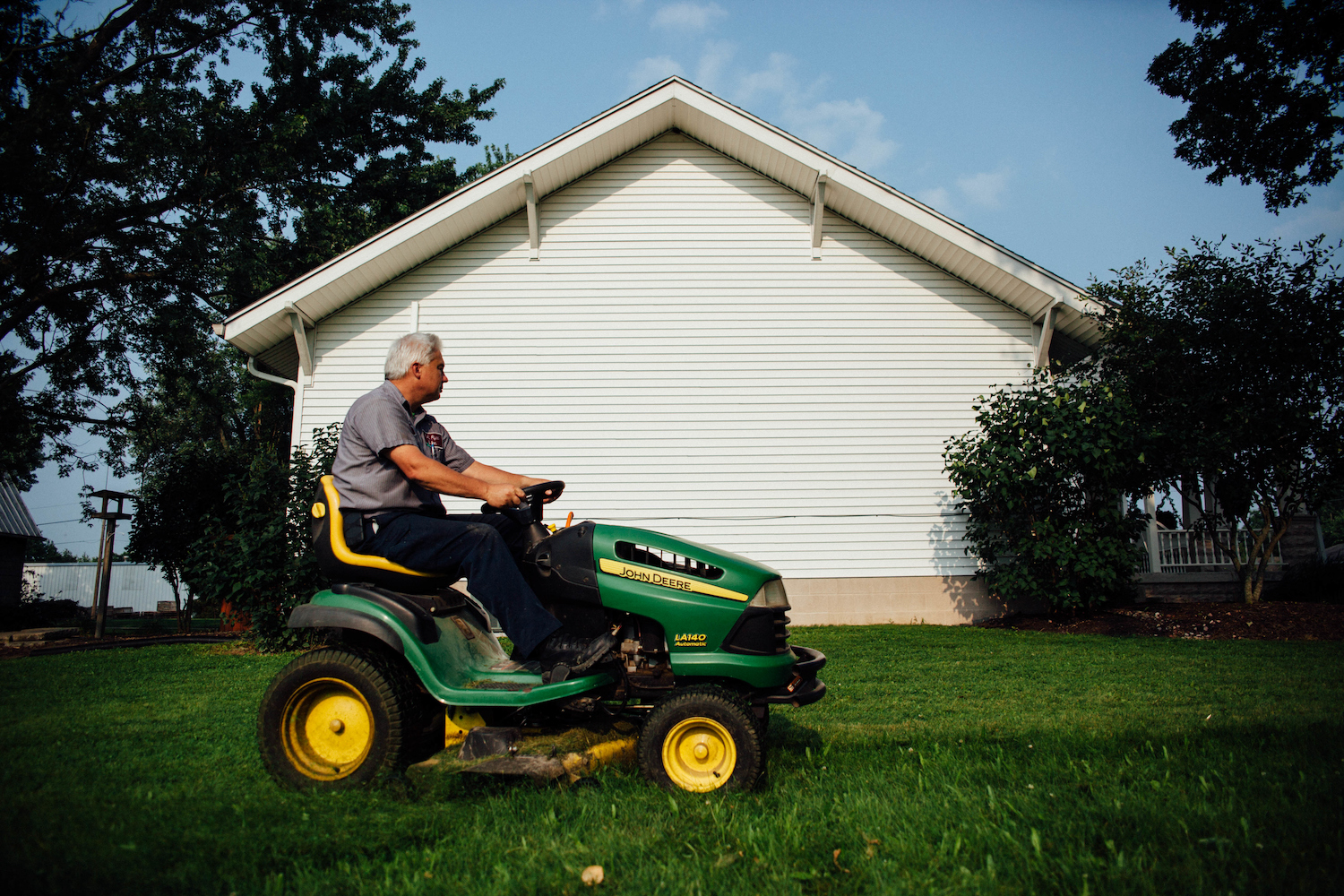 A man mowing a lawn on a riding lawn mower