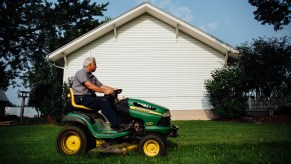 A man mowing a lawn on a riding lawn mower