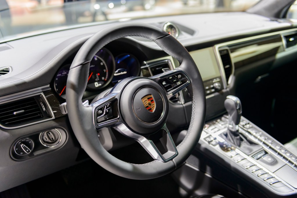 An interior shot of the steering wheel and dashboard of a Porsche Macan