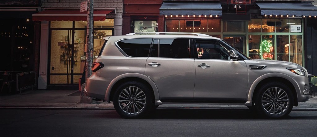 A gold 2021 Infiniti QX80 parked in front of a restaurant. 