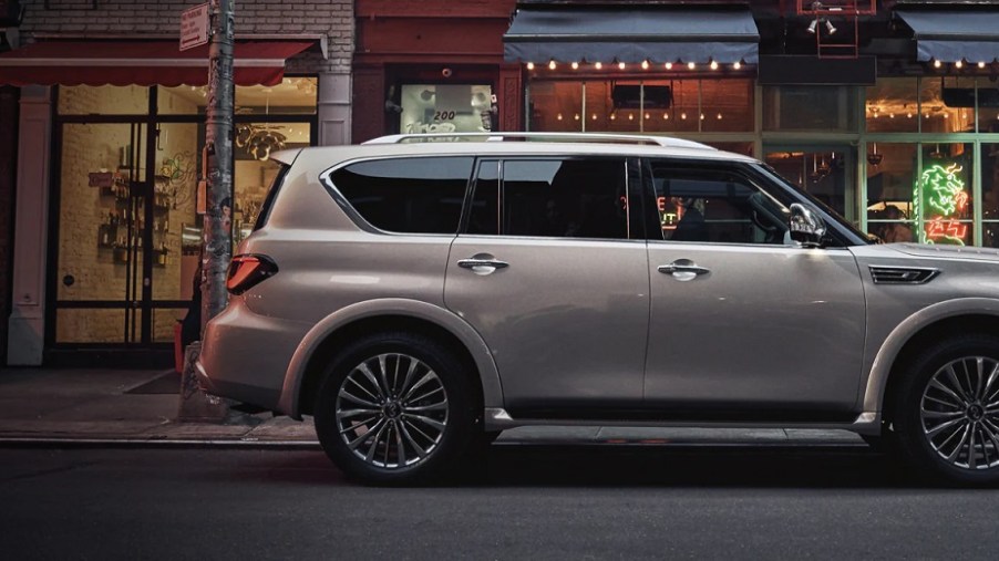 A gold 2021 Infiniti QX80 sitting outside of a store.