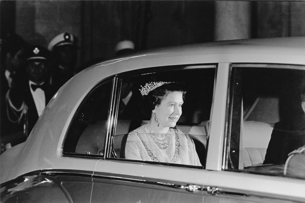 Queen Elizabeth II in the rear seat of a car