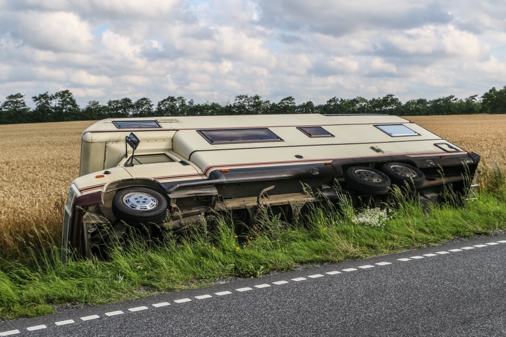 A recreational vehicle on its side in a ditch