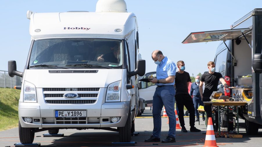 Saxony, Laatzen: Matthias Krebs (r), member of the Traffic, Technology and Environment Team at ADAC Lower Saxony / Saxony-Anhalt, talks to a motorhome driver after weighing the vehicle's weight