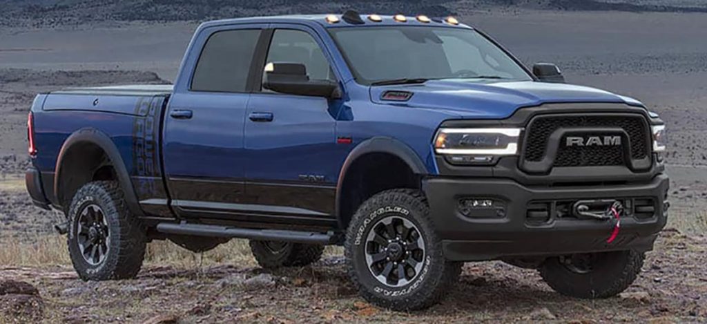 A blue 2021 Ram Power Wagon parked on dirt and gravel.