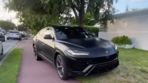 An image of a Lamborghini Urus parked on a sidewalk.