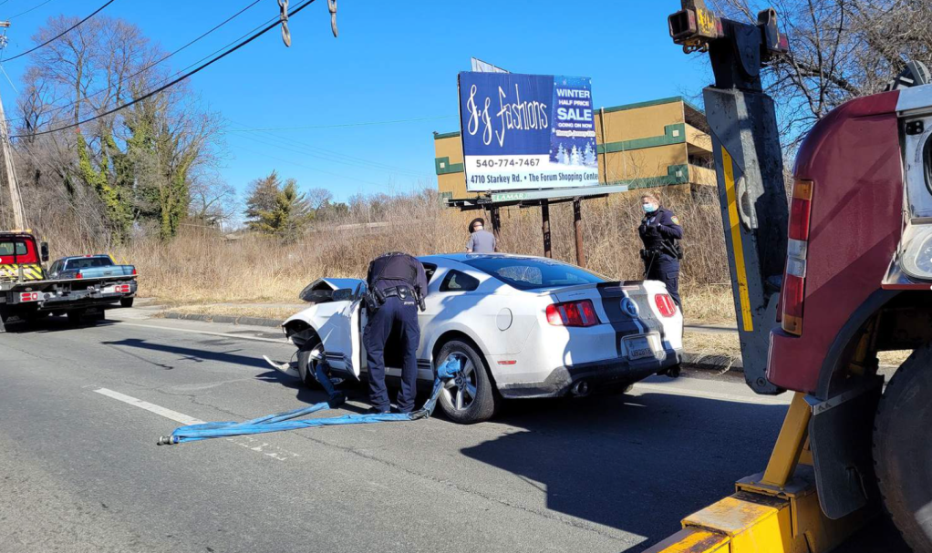 An image of a crashed Ford Mustang outdoors.