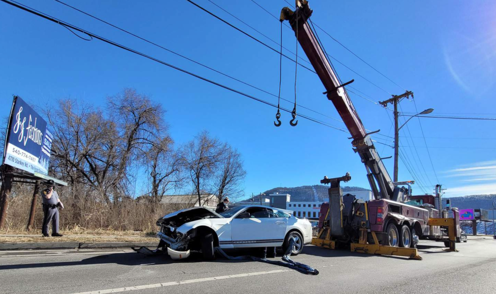 An image of a crashed Ford Mustang outdoors.