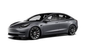 A dark gray Tesla model 3 against a white background.
