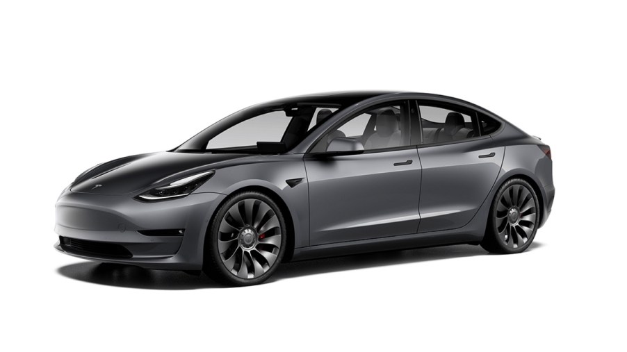 A dark gray Tesla model 3 against a white background.