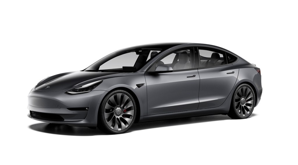 A dark gray 2021 Tesla Model 3 against a white background.