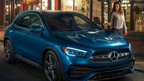 a light blue 2021 mercedes-benz GLA-Class on the curb of a fashionable night time cityscape