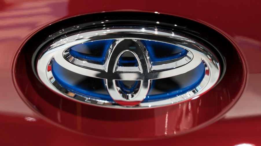 A close-up of a silver Toyota logo on the front of a red vehicle