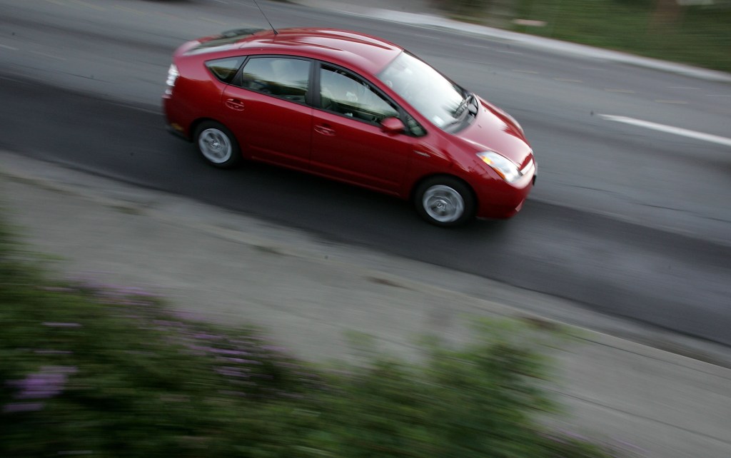 A Toyota Prius hybrid vehicle is seen driving down the street