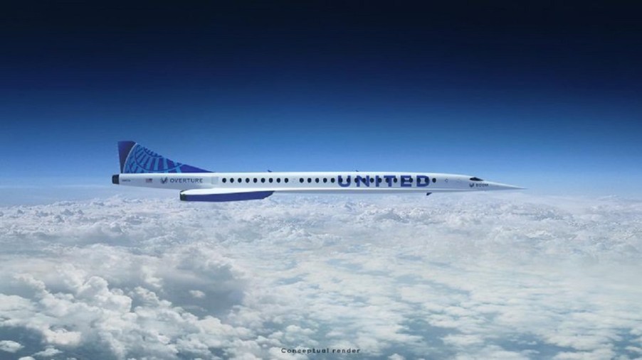 A white plane with a blue "United" printed on the side, flying high above the clouds.