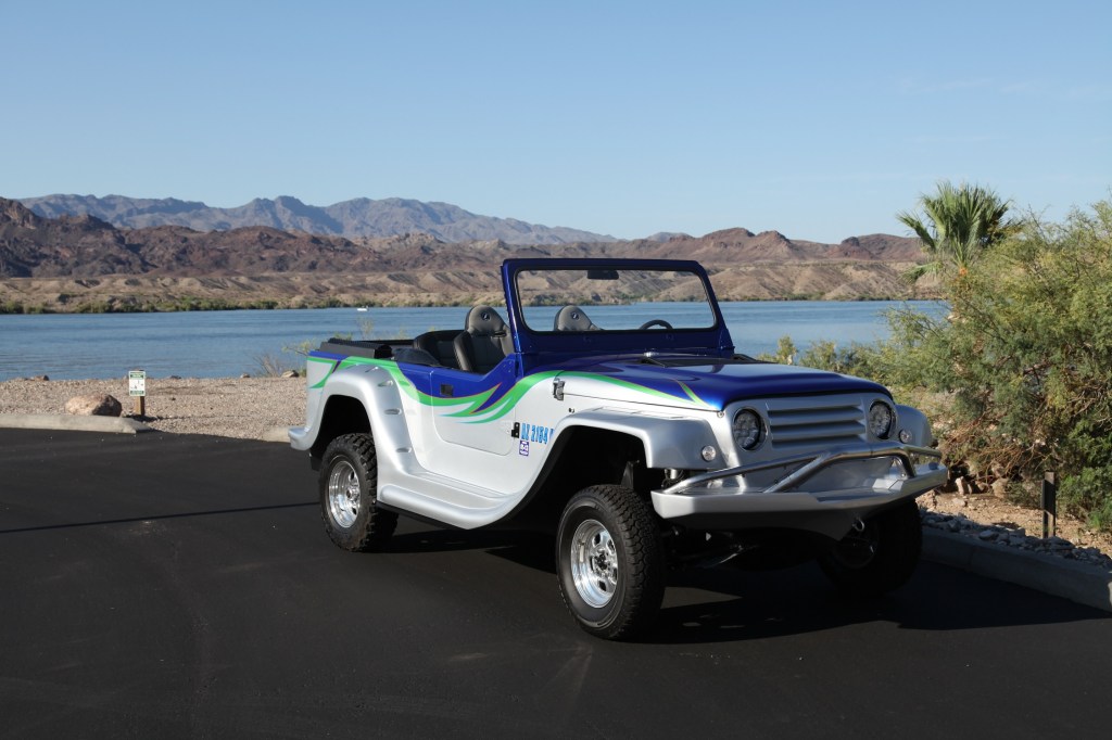 A silver-green-and-blue WaterCar Panther on a road by a lake