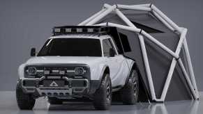 A white Alpha Wolf+ Cloudbreak electric pickup truck with a geodesic tent