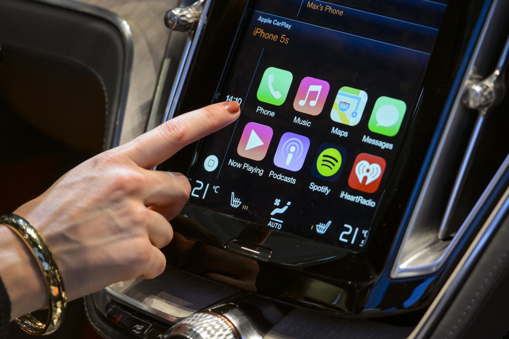 A visitor presses the new Apple's CarPlay touch-screen commands inside the Volvo Estate concept car.