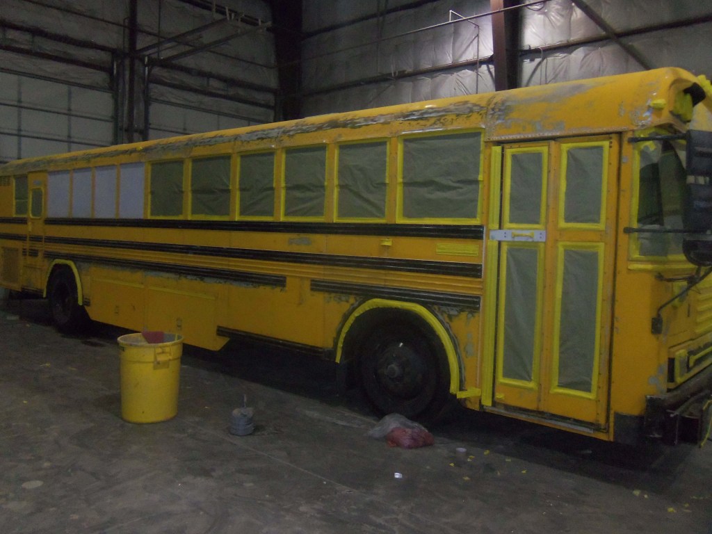 A yellow bus prepared for painting