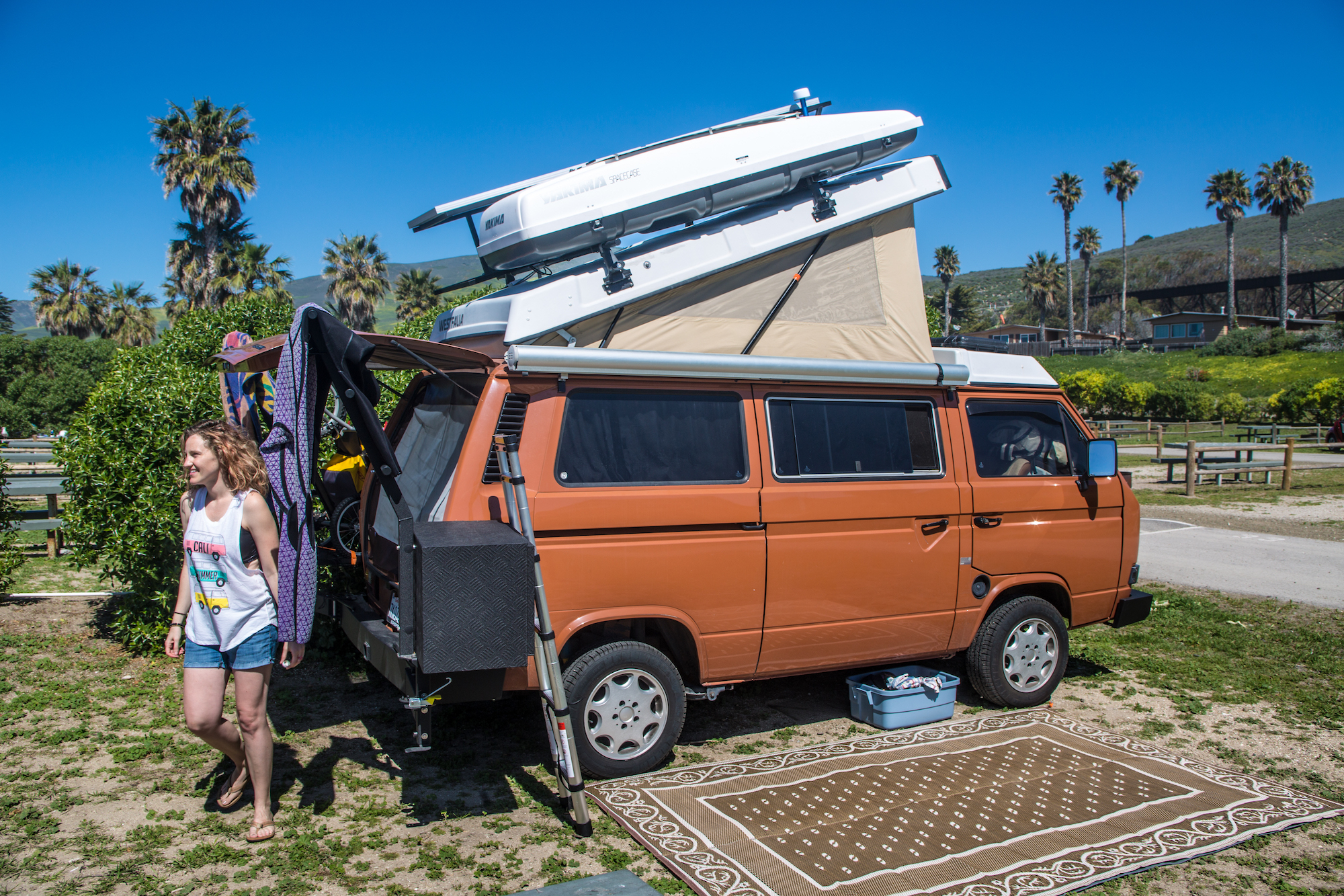 A family shows off their Volkswagen Westfalia pop-up camper rigged with solar panels on the roof on March 16, 2016, near Jalama Beach, California
