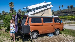 A family shows off their Volkswagen Westfalia pop-up camper rigged with solar panels on the roof on March 16, 2016, near Jalama Beach, California