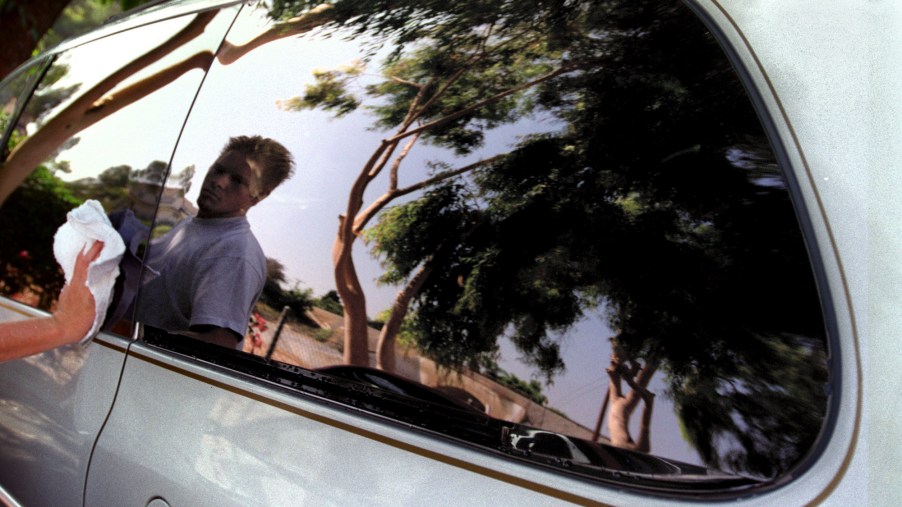 Teenager Colby McGehee details a silver minivan in August 1998