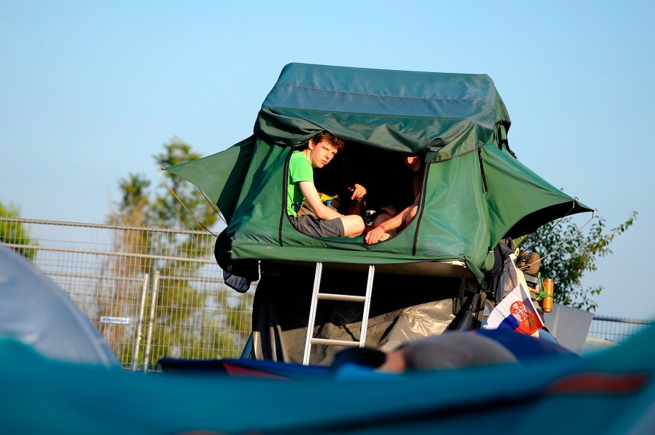 Two people in a tent placed on a car's roof