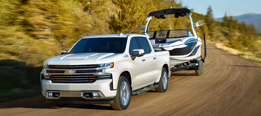 A white 2021 Chevy Silverado 1500 towing a boat
