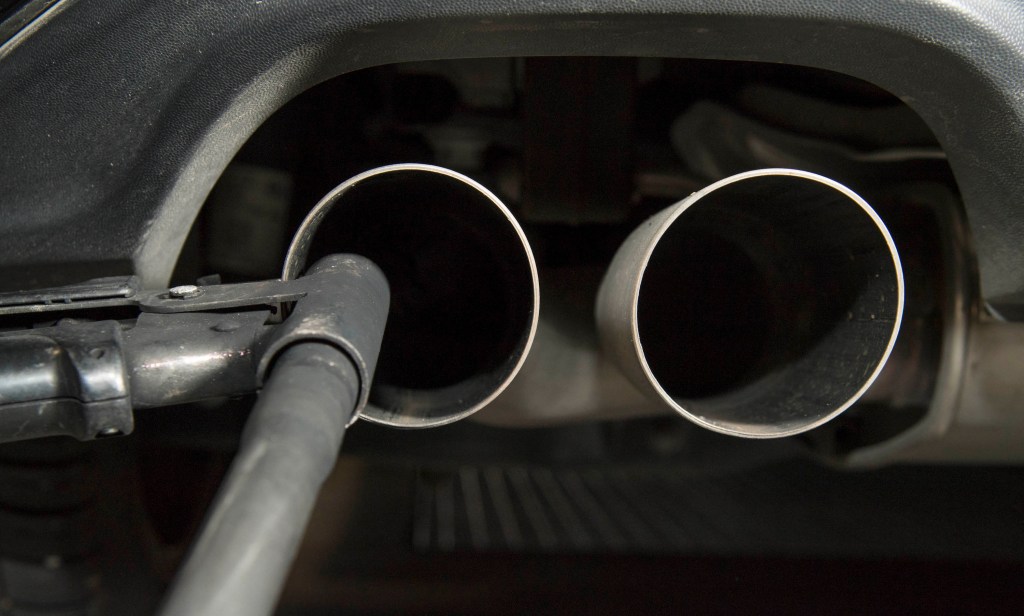 A hose sits near the exhaust of a diesel vehicle to perform an emissions test