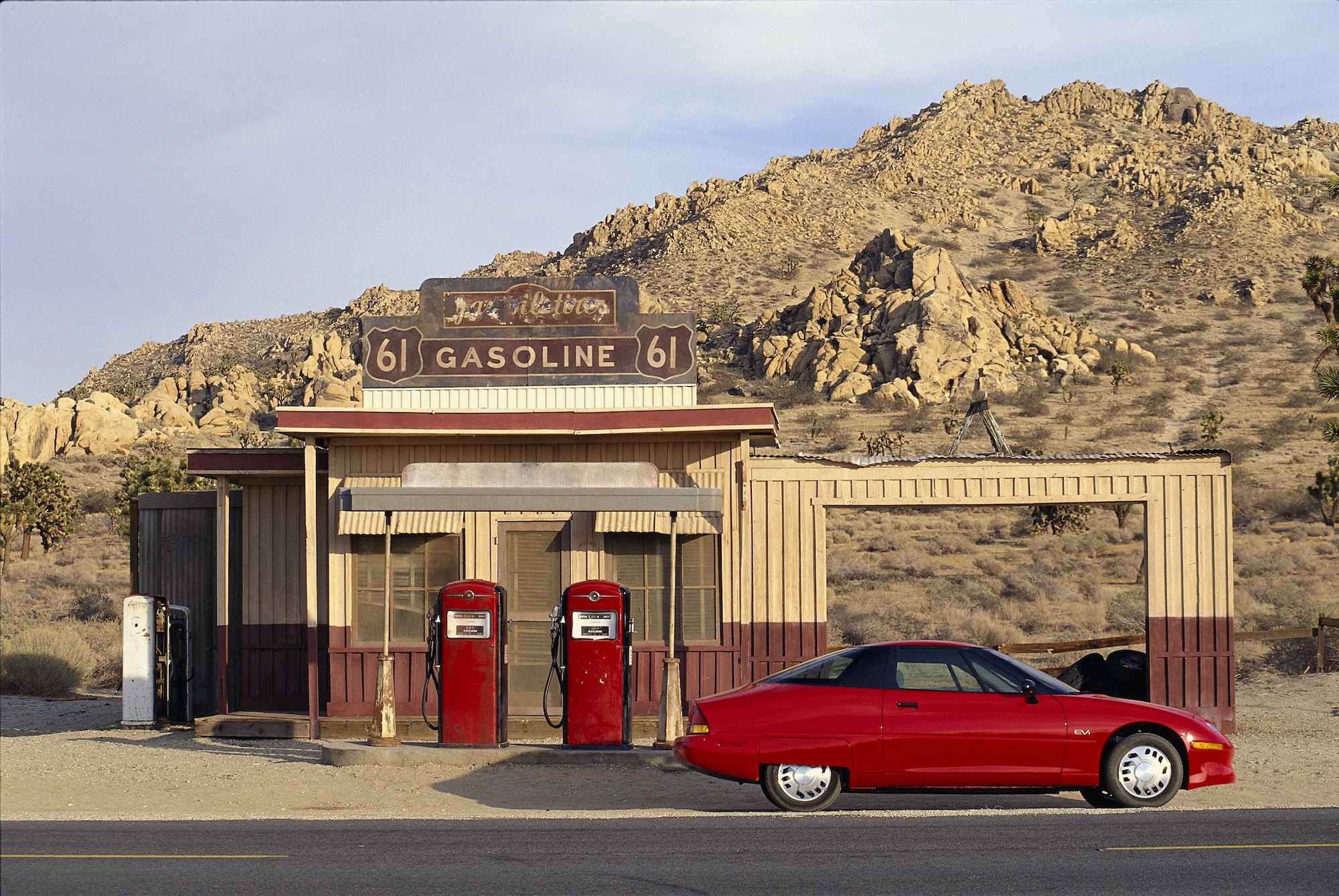 A red GM EV1 electric car parked at a rural gas station in April 1997