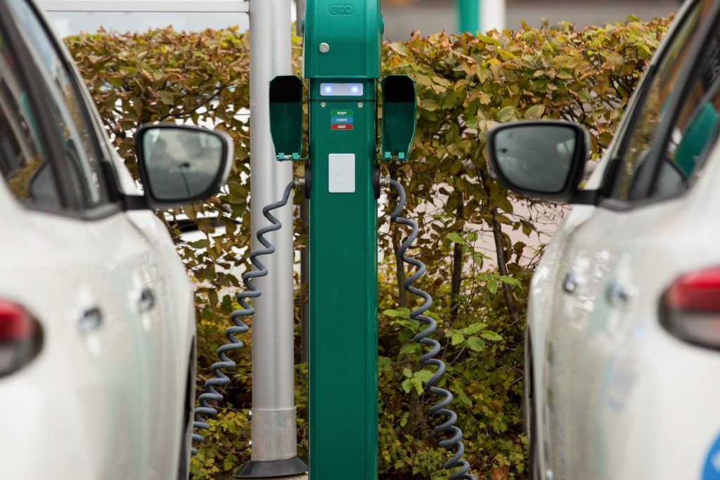 Two white electric vehicles charging side by side