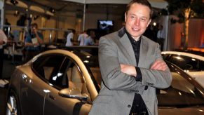 Elon Musk stands in front of Tesla Model S.