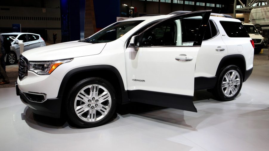 A white gmc acadia with an open drivers door