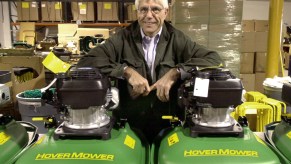 Nick Nikazmerad, president of Eastman Industries, leans on two hover lawn mowers in December 2004