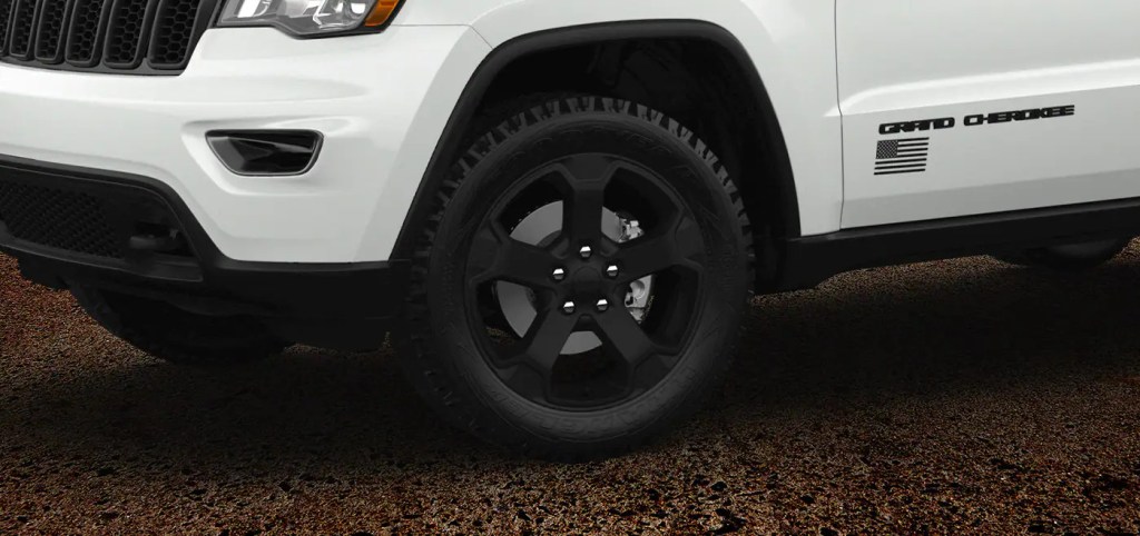 The black wheel of the white Jeep Grand Cherokee Freedom
