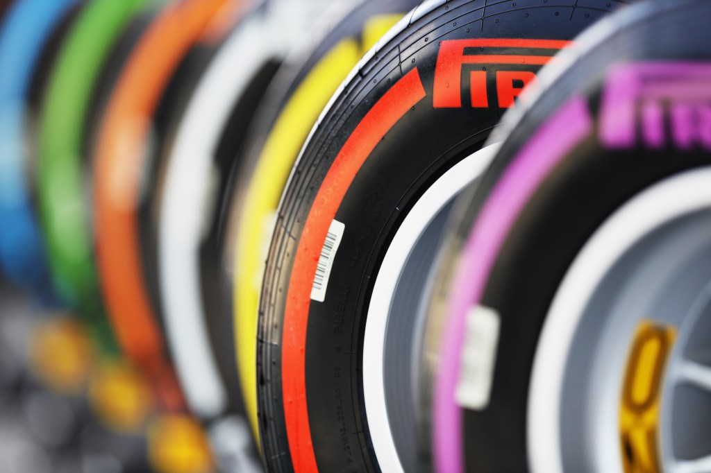A row of Pirelli racing tires, each with a brightly colored stripe